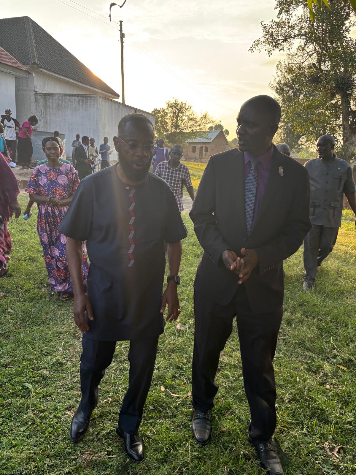 Two project leaders walking across grass toward the launch site at sunset