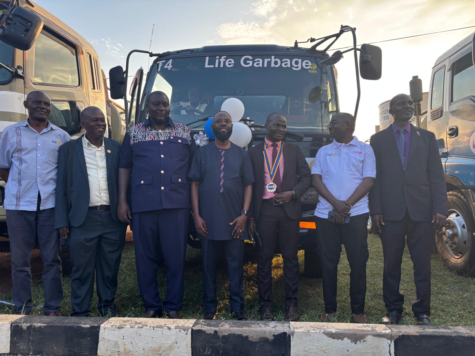 Rotarians and officials standing in front of the T4 Life garbage collection truck, decorated with balloons